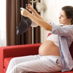 young-pregnant-woman-looking-at-maternity-bra-2023-11-27-05-09-58-utc